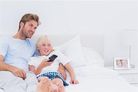 simsearch:400-06872329,k - Father and son watching TV together in bed Stock Photo - Budget Royalty-Free & Subscription, Code: 400-06886548