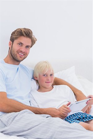 simsearch:400-06872329,k - Handsome father and his son using a tablet in bed Stock Photo - Budget Royalty-Free & Subscription, Code: 400-06886540
