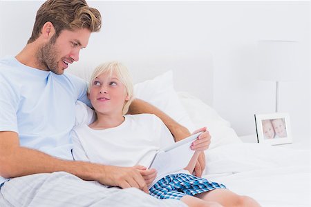 simsearch:400-06872329,k - Father and son using a tablet together in bed Stock Photo - Budget Royalty-Free & Subscription, Code: 400-06886542