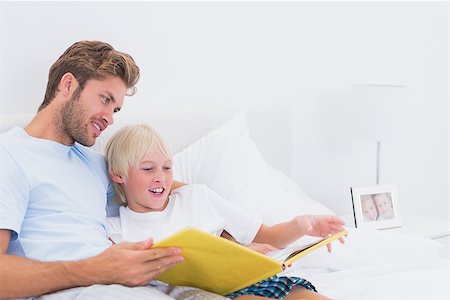 father reading to child portrait - Portrait of a smiling father reading a story to his son in bed Stock Photo - Budget Royalty-Free & Subscription, Code: 400-06886554