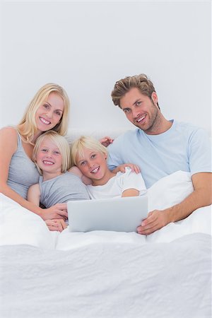 simsearch:400-06872329,k - Cheerful family using a laptop lying in bed Stock Photo - Budget Royalty-Free & Subscription, Code: 400-06886585