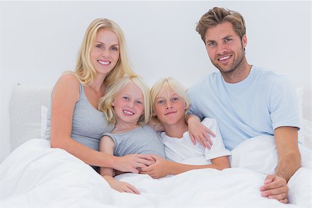 simsearch:400-06872329,k - Portrait of a cheerful family sitting in bed Stock Photo - Budget Royalty-Free & Subscription, Code: 400-06886580