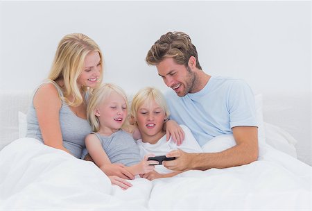 simsearch:400-06872329,k - Beautiful family using a smartphone in bed Stock Photo - Budget Royalty-Free & Subscription, Code: 400-06886582