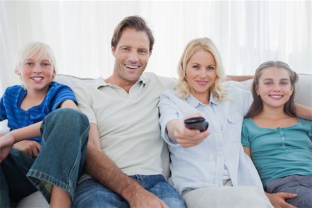 Parents posing with children and watching television sitting on a couch Stock Photo - Budget Royalty-Free & Subscription, Code: 400-06887753