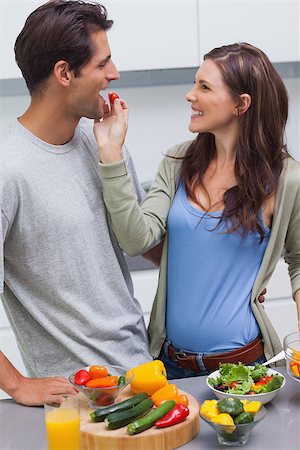 pimento - Attractive woman feeding her husband cherry tomato in kitchen Stock Photo - Budget Royalty-Free & Subscription, Code: 400-06888327