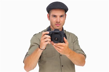 peaked cap - Serious man in peaked cap taking photo on white background Stock Photo - Budget Royalty-Free & Subscription, Code: 400-06880604