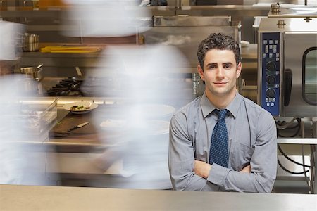 Smiling waiter standing in busy kitchen Stock Photo - Budget Royalty-Free & Subscription, Code: 400-06882099