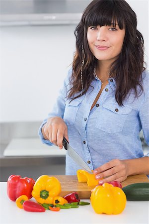 simsearch:6109-08390293,k - Pretty brunette slicing vegetables at kitchen counter Stock Photo - Budget Royalty-Free & Subscription, Code: 400-06891384