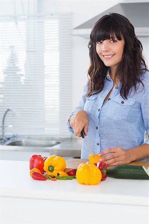simsearch:6109-08390293,k - Pretty brunette slicing pepper at kitchen counter Stock Photo - Budget Royalty-Free & Subscription, Code: 400-06891385