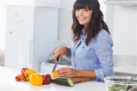 simsearch:6109-08390293,k - Pretty brunette chopping peppers at kitchen counter Stock Photo - Budget Royalty-Free & Subscription, Code: 400-06891388