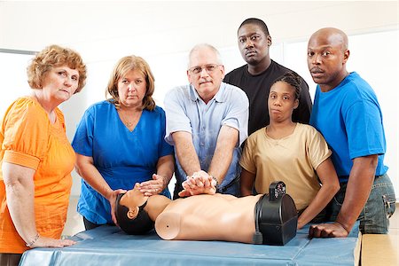 simsearch:400-07411030,k - Diverse adult education class practicing CPR on a mannequin.  Serious expressions Stock Photo - Budget Royalty-Free & Subscription, Code: 400-06917334