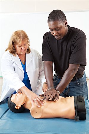 simsearch:400-07411030,k - Doctor or nurse instructs an adult student in CPR life-saving techniques. Stock Photo - Budget Royalty-Free & Subscription, Code: 400-06917333