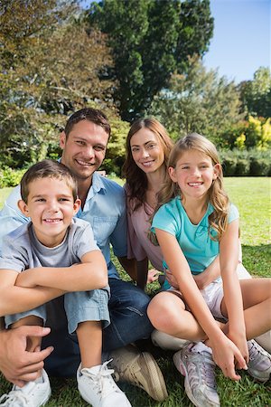 family and park and camera - Cheerful family relaxing outside in the park smiling at camera Stock Photo - Budget Royalty-Free & Subscription, Code: 400-06934055