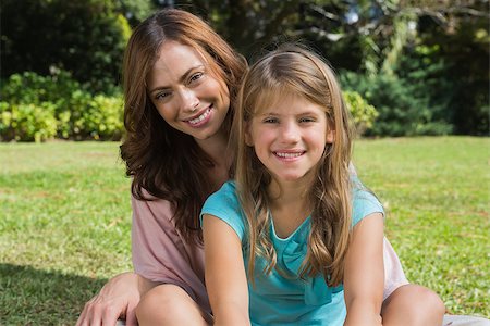 family and park and camera - Smiling mother and daughter on the grass in park looking at camera Stock Photo - Budget Royalty-Free & Subscription, Code: 400-06934078