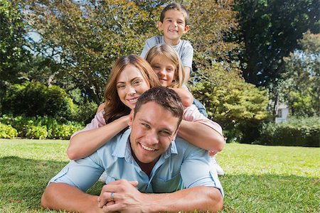 family and park and camera - Happy family members lying on each other in the park smiling at camera Stock Photo - Budget Royalty-Free & Subscription, Code: 400-06934090