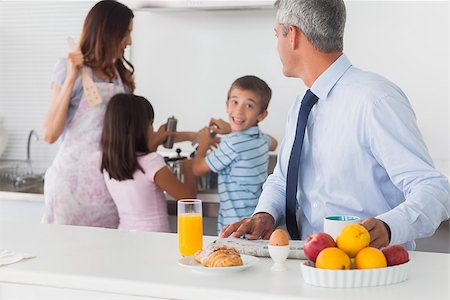 Father looking at his family cooking in the kitchen in the morning before work Stock Photo - Budget Royalty-Free & Subscription, Code: 400-06930151