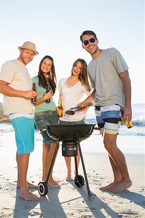simsearch:6109-06781569,k - Happy friends on the beach looking at camera while having barbecue together Stock Photo - Budget Royalty-Free & Subscription, Code: 400-06930603