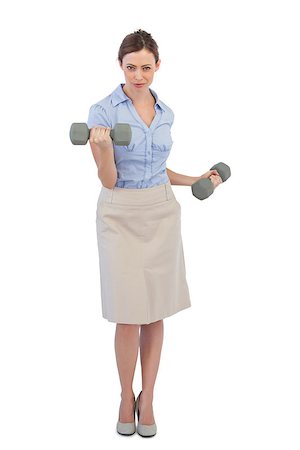 Tough businesswoman lifting dumbbells looking at camera against white background Foto de stock - Super Valor sin royalties y Suscripción, Código: 400-06932081