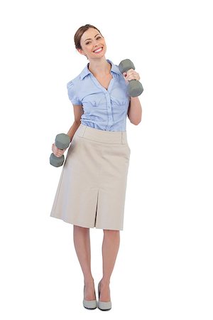 Happy businesswoman lifting dumbbells looking at camera against white background Foto de stock - Super Valor sin royalties y Suscripción, Código: 400-06932082