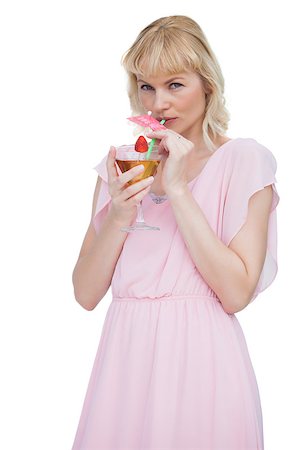 fresh-faced - Pretty blond woman drinking cocktail and looking at camera against white background Stock Photo - Budget Royalty-Free & Subscription, Code: 400-06932536