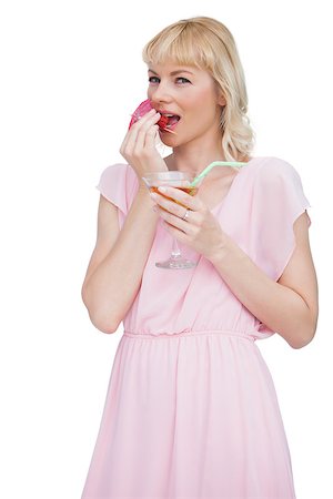fresh-faced - Pretty blond woman with cocktail eating fruits against white background Stock Photo - Budget Royalty-Free & Subscription, Code: 400-06932538