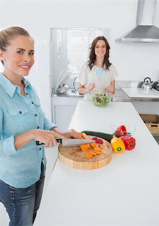 simsearch:6109-08390293,k - Smiling women cooking together  in the kitchen and looking at camera Stock Photo - Budget Royalty-Free & Subscription, Code: 400-06932724