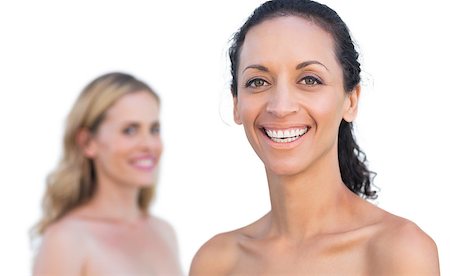 Smiling brunette on foreground with blonde behind on white background Foto de stock - Super Valor sin royalties y Suscripción, Código: 400-06932974