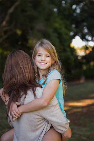 family and park and camera - Mother holding her lovely daughter in arms smiling at camera in the park Stock Photo - Budget Royalty-Free & Subscription, Code: 400-06933979