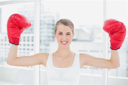 Cheerful competitive woman with red boxing gloves cheering up in bright sports hall Stock Photo - Budget Royalty-Free & Subscription, Code: 400-06959626