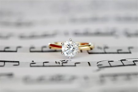 simsearch:400-04570412,k - Ideal cut solitaire diamond on yellow gold ring onto music score. Top view. Stock Photo - Budget Royalty-Free & Subscription, Code: 400-07035978
