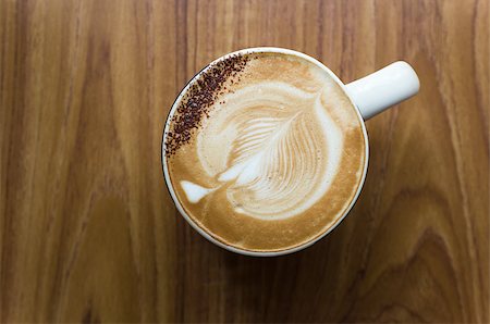 Leaf shaped coffee milk foam in white ceramic cup on wood table Stock Photo - Budget Royalty-Free & Subscription, Code: 400-07046263