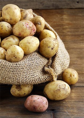 fresh organic potatoes on a wooden background, rustic style Stock Photo - Budget Royalty-Free & Subscription, Code: 400-07048277