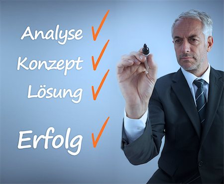 Attractive businessman writing a success checklist in german on grey background Stock Photo - Budget Royalty-Free & Subscription, Code: 400-07056898