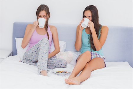 Friends chatting and drinking coffee sitting up in bed wearing pajamas Stock Photo - Budget Royalty-Free & Subscription, Code: 400-07057359