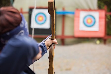 Brunette about to shoot arrow at the archery range Stock Photo - Budget Royalty-Free & Subscription, Code: 400-07058548