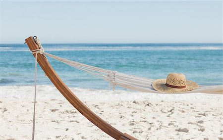 Shot of a straw hat lying on hammock against ocean Foto de stock - Super Valor sin royalties y Suscripción, Código: 400-07059233