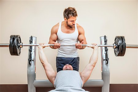 A handsome young muscular sports man doing weight lifting and gets help from his friend Stock Photo - Budget Royalty-Free & Subscription, Code: 400-07050910