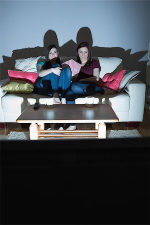 Two happy friends on the couch watching tv together in the dark at home in the living room Foto de stock - Super Valor sin royalties y Suscripción, Código: 400-07060025