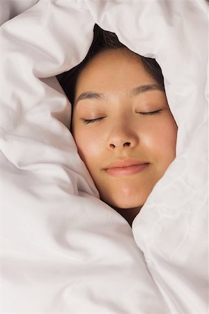 Young asian woman all wrapped up in her duvet at home in bedroom Stock Photo - Budget Royalty-Free & Subscription, Code: 400-07060662