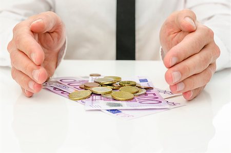 energy money - Male hands around Euro banknotes and coins as if they are giving power and energy to money. Stock Photo - Budget Royalty-Free & Subscription, Code: 400-07089303