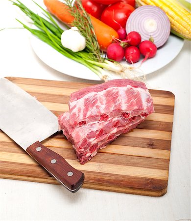 chopping fresh pork ribs with vegetables and herbs ready to cook Stock Photo - Budget Royalty-Free & Subscription, Code: 400-07095349