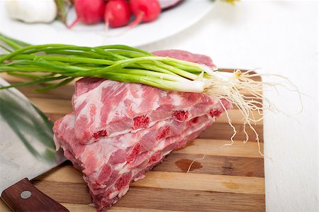 chopping fresh pork ribs with vegetables and herbs ready to cook Stock Photo - Budget Royalty-Free & Subscription, Code: 400-07095350