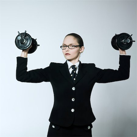 studio shot portrait of one caucasian young bsuiness woman holding weights Stock Photo - Budget Royalty-Free & Subscription, Code: 400-07097653