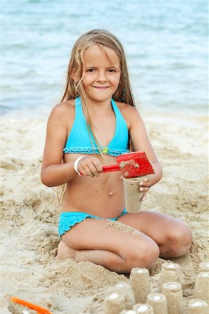 simsearch:400-04423521,k - Little girl playing with sand on the beach - building little towers Photographie de stock - Aubaine LD & Abonnement, Code: 400-07091063