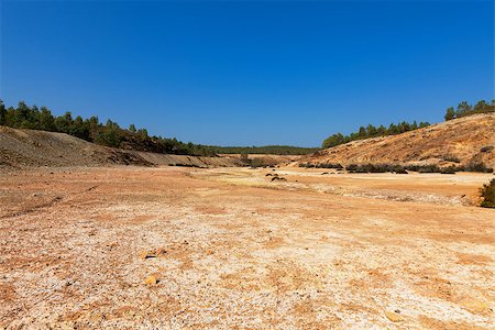 dusty environment - Empty river-bed in a dry dusty landscape with distant trees on the horizon Stock Photo - Budget Royalty-Free & Subscription, Code: 400-07092131