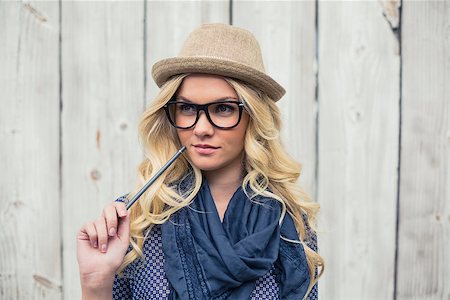 simsearch:400-04655693,k - Pensive trendy blonde holding pencil on wooden background Stock Photo - Budget Royalty-Free & Subscription, Code: 400-07126958