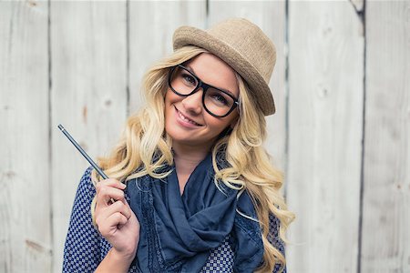 simsearch:400-04722731,k - Smiling trendy blonde holding pencil on wooden background Stock Photo - Budget Royalty-Free & Subscription, Code: 400-07126959