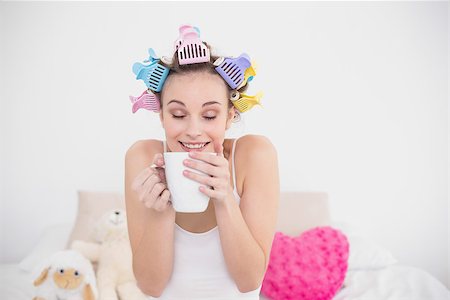 simsearch:400-07129766,k - Funny natural brown haired woman in hair curlers enjoying coffee smell in bright bedroom Stock Photo - Budget Royalty-Free & Subscription, Code: 400-07129724
