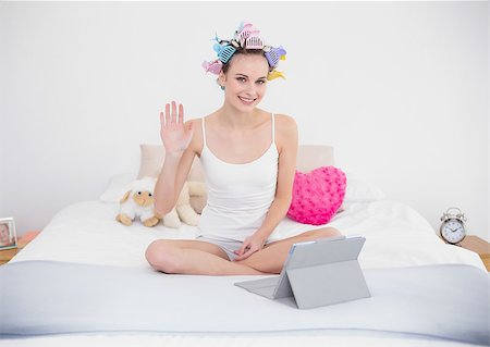 simsearch:400-07129766,k - Joyful natural brown haired woman in hair curlers chatting online with a tablet pc in bright bedroom Stock Photo - Budget Royalty-Free & Subscription, Code: 400-07129727