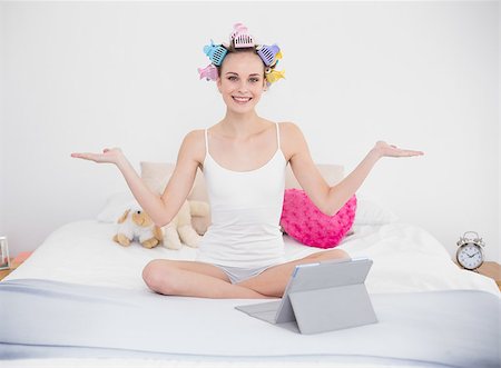 simsearch:400-07129766,k - Relaxed natural brown haired woman in hair curlers moving her arms in bright bedroom Stock Photo - Budget Royalty-Free & Subscription, Code: 400-07129728